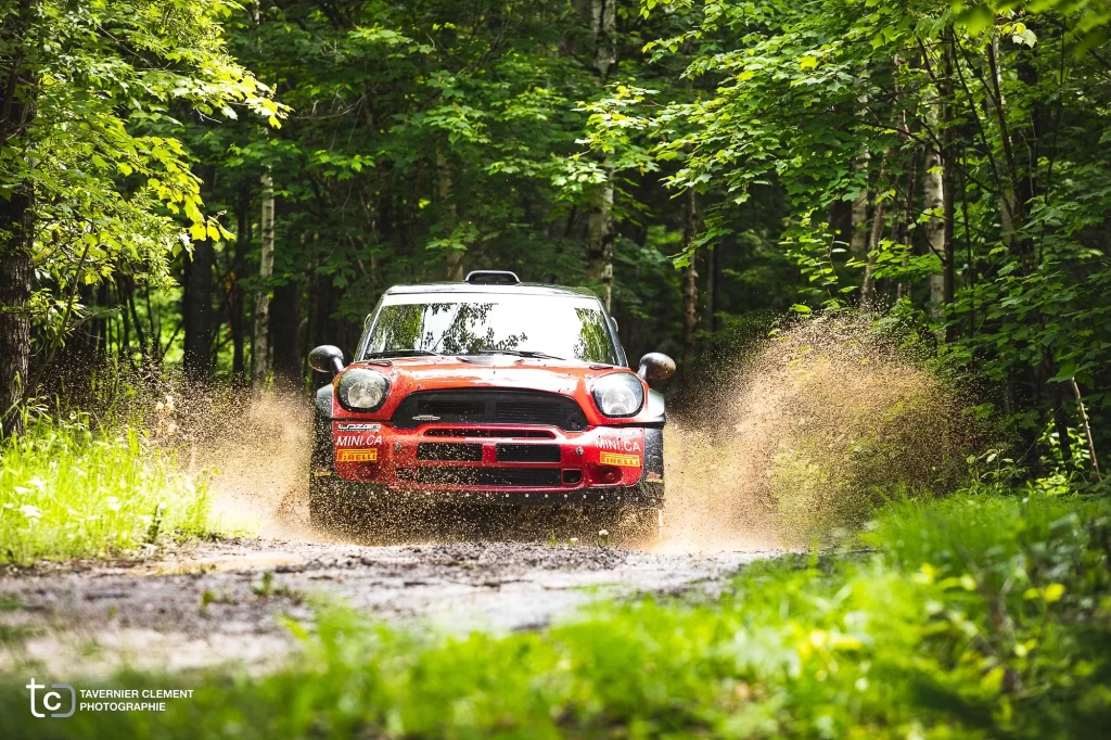 Mini Cooper qui roule sur une piste dans la forêt