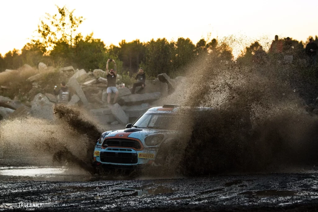 Mini Cooper qui roule dans la boue en projetant celle-ci sur les côté de la voiture