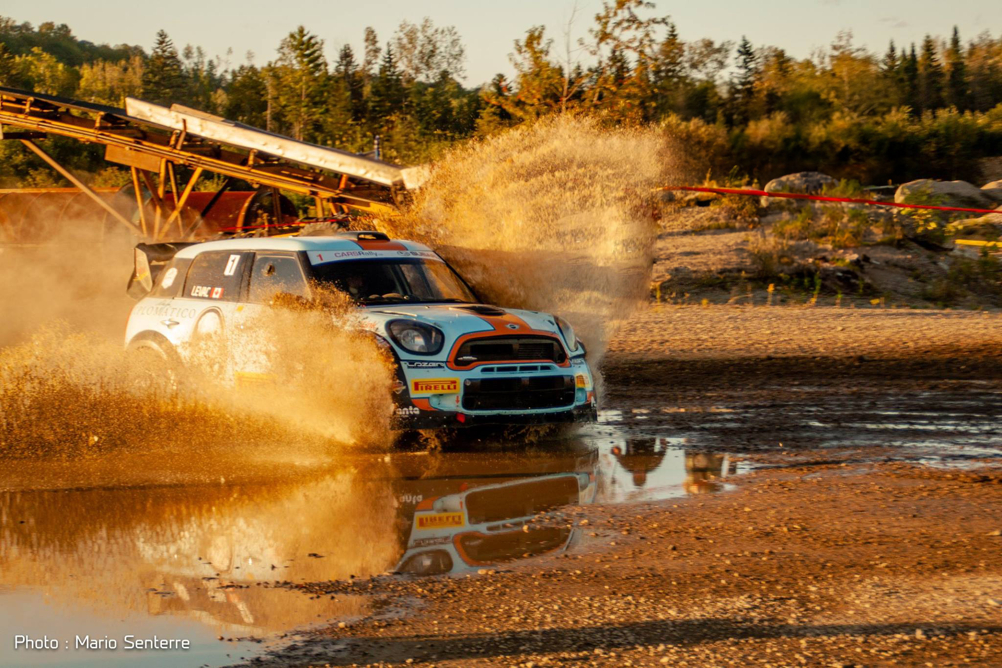 Mini Cooper qui roule dans la boue en projetant celle-ci sur les côté de la voiture